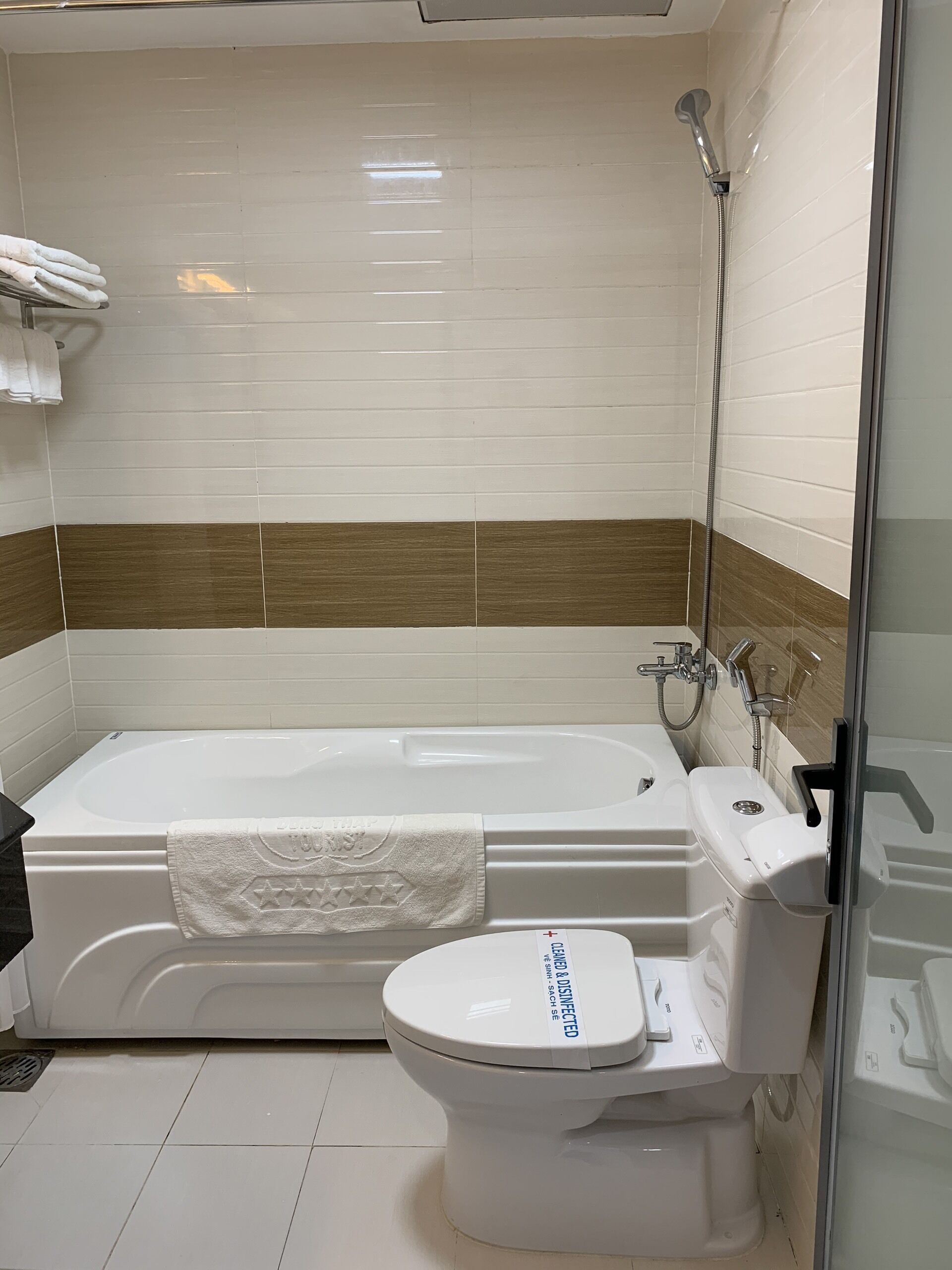 Een badkamer met een bad, toilet en douche.