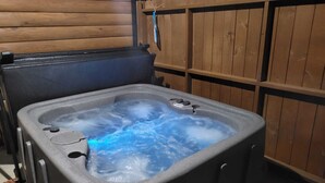 A hot tub with a wooden fence in the background. - Jason's Log Cabin Retreat w/ Hot tub, rockers, swing, game room, & 3 King beds (Sevierville)