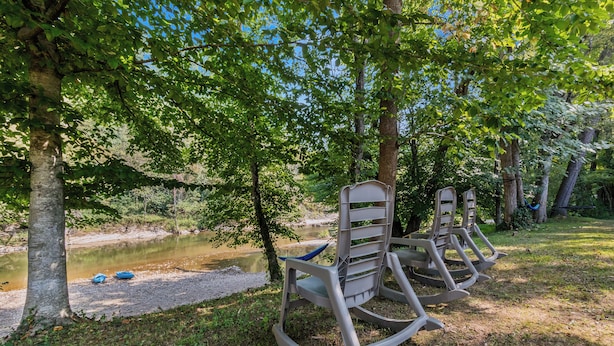 Un espacio al aire libre tranquilo con mecedoras y un pequeño estanque.