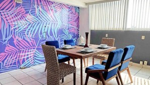 A dining area with a table set for four, surrounded by blue upholstered chairs. - Private House with 8 Bedrooms: Sleeps 16 | Across from Jalisco Stadium. (Independencia)