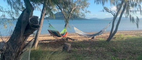 Una playa cerca, sillas reclinables de playa, toallas de playa