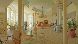 Un hall d’entrée spacieux, doté de hauts plafonds, de grandes colonnes et d’un magnifique lustre.