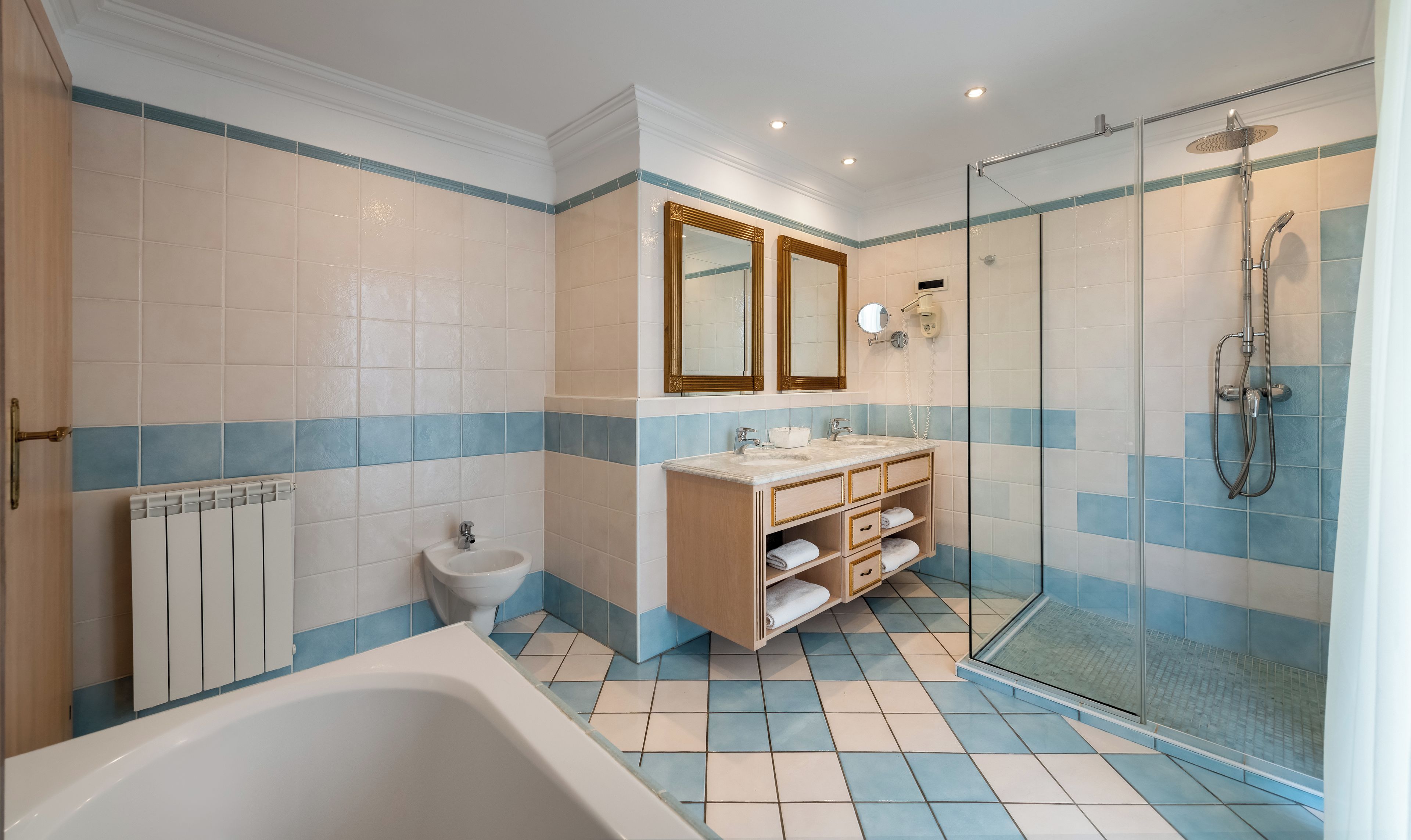 Un bagno con una vasca, un lavandino, un water e una doccia.