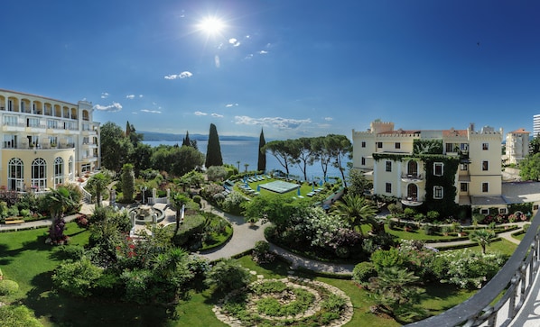 Ein Hotel mit Pool, üppigem Garten und Meerblick.