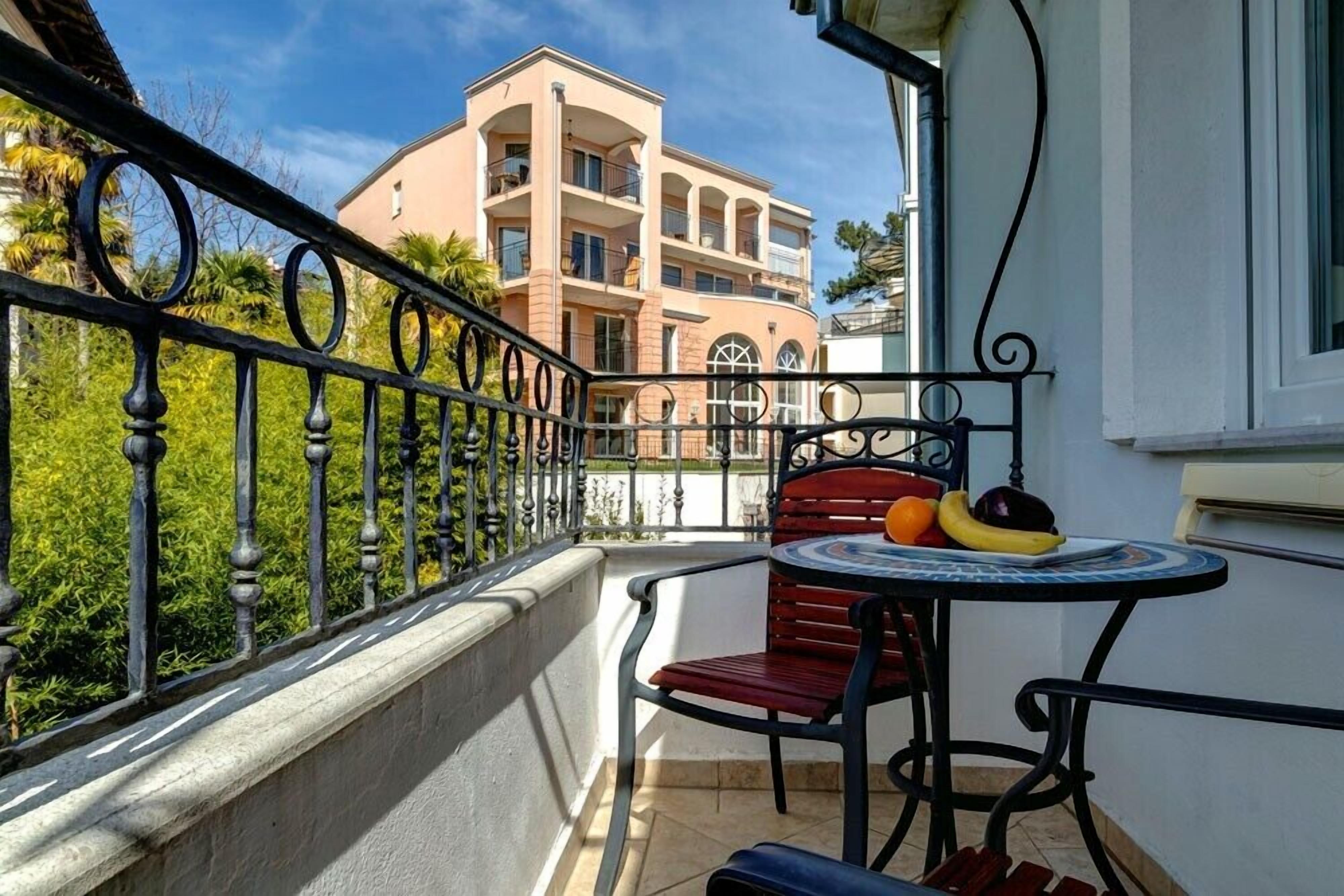 Un balcón con una mesa, una silla y vista a un edificio.