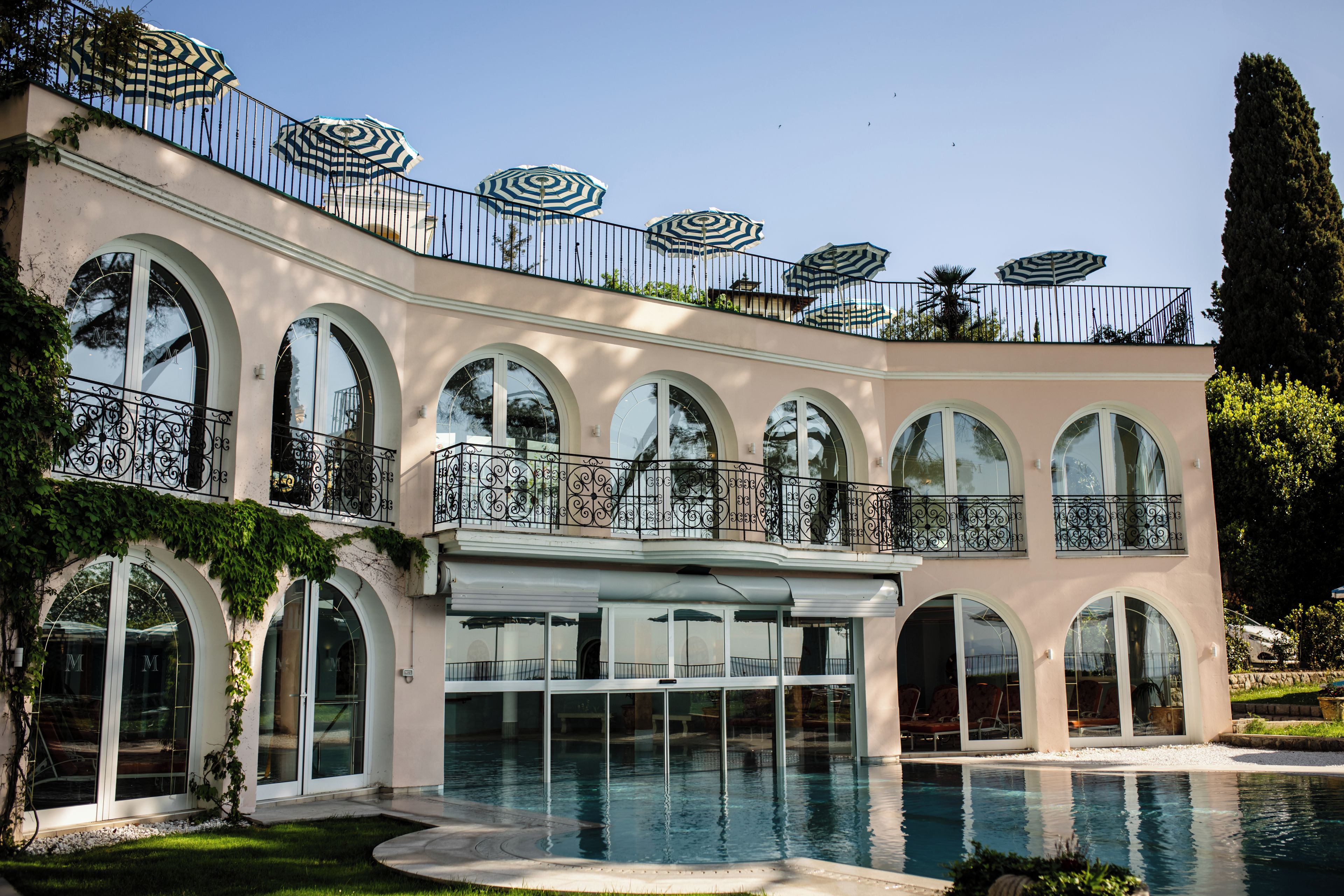 A large building with multiple arched windows and a swimming pool.