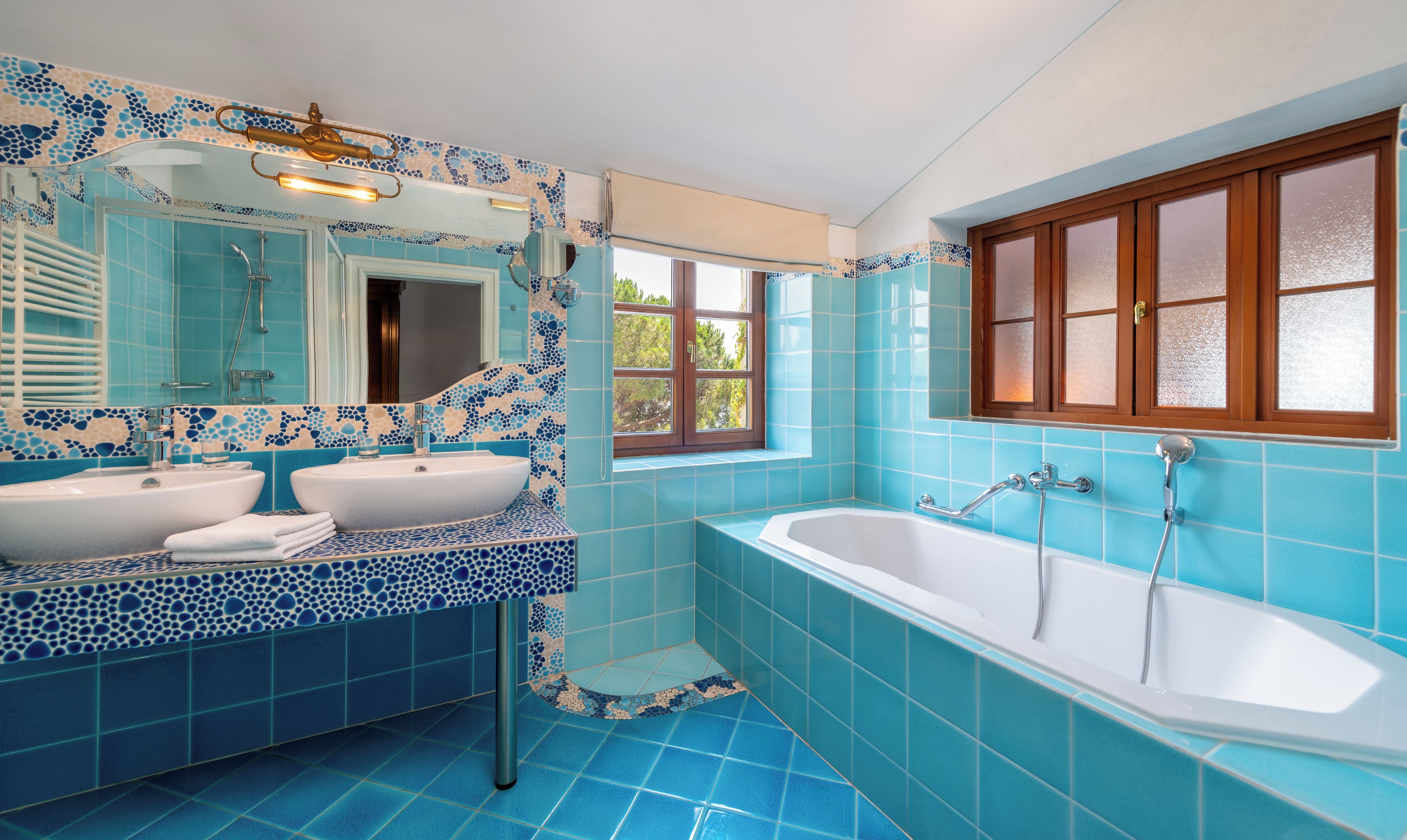 Une salle de bain avec deux lavabos, une baignoire et une fenêtre.