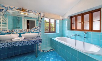 Un bagno con due lavandini, una vasca e una finestra.