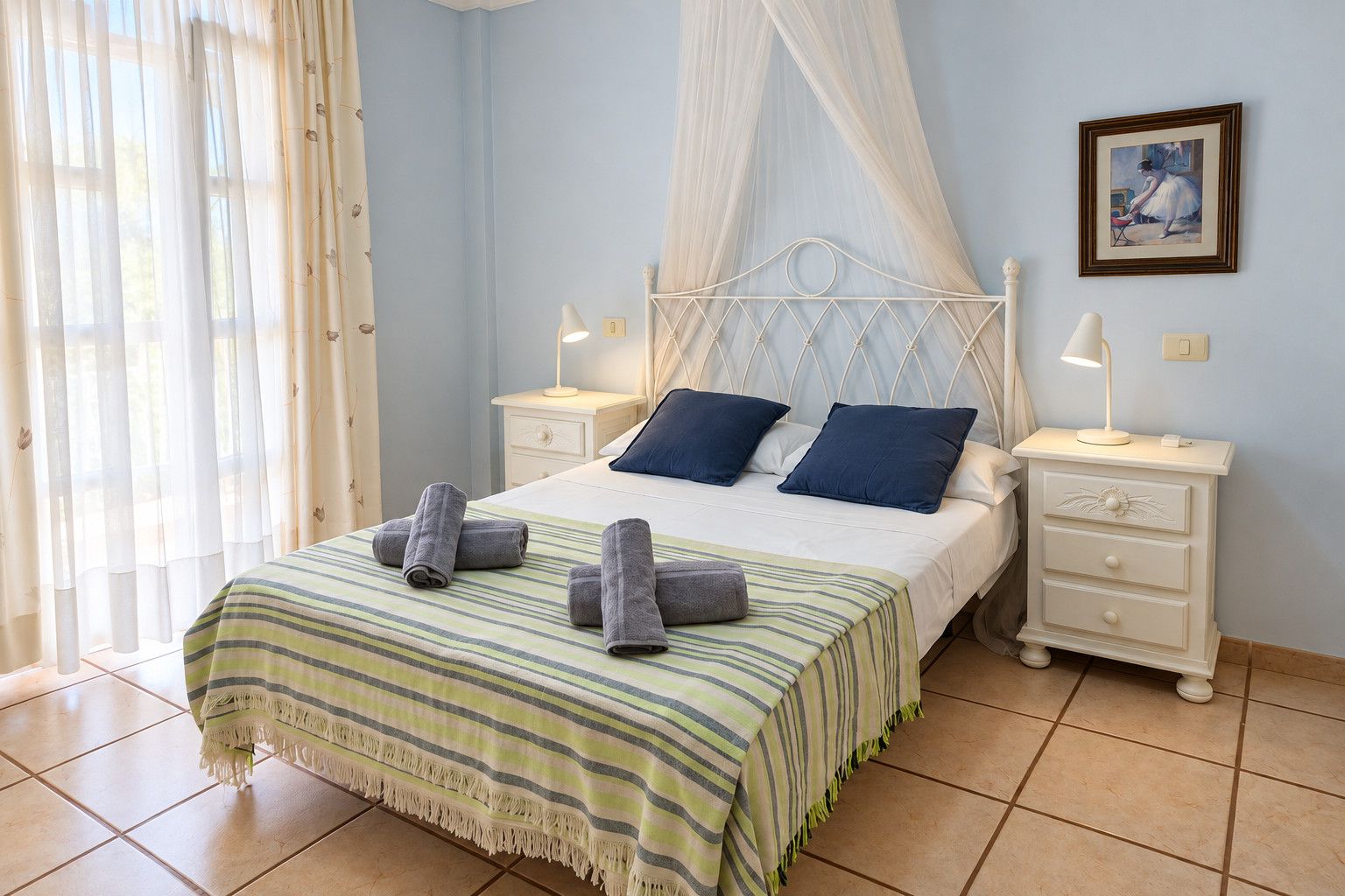 Un dormitorio con una cama, dos mesitas de noche, un cabecero y un cuadro enmarcado en la pared.
