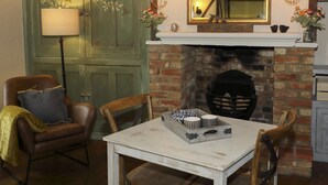 Una habitación acogedora con chimenea, una mesa de comedor y un sillón de cuero.