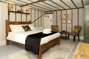 Een slaapkamer met een houten bed, een nachtkastje, een stoel en een groene kast.