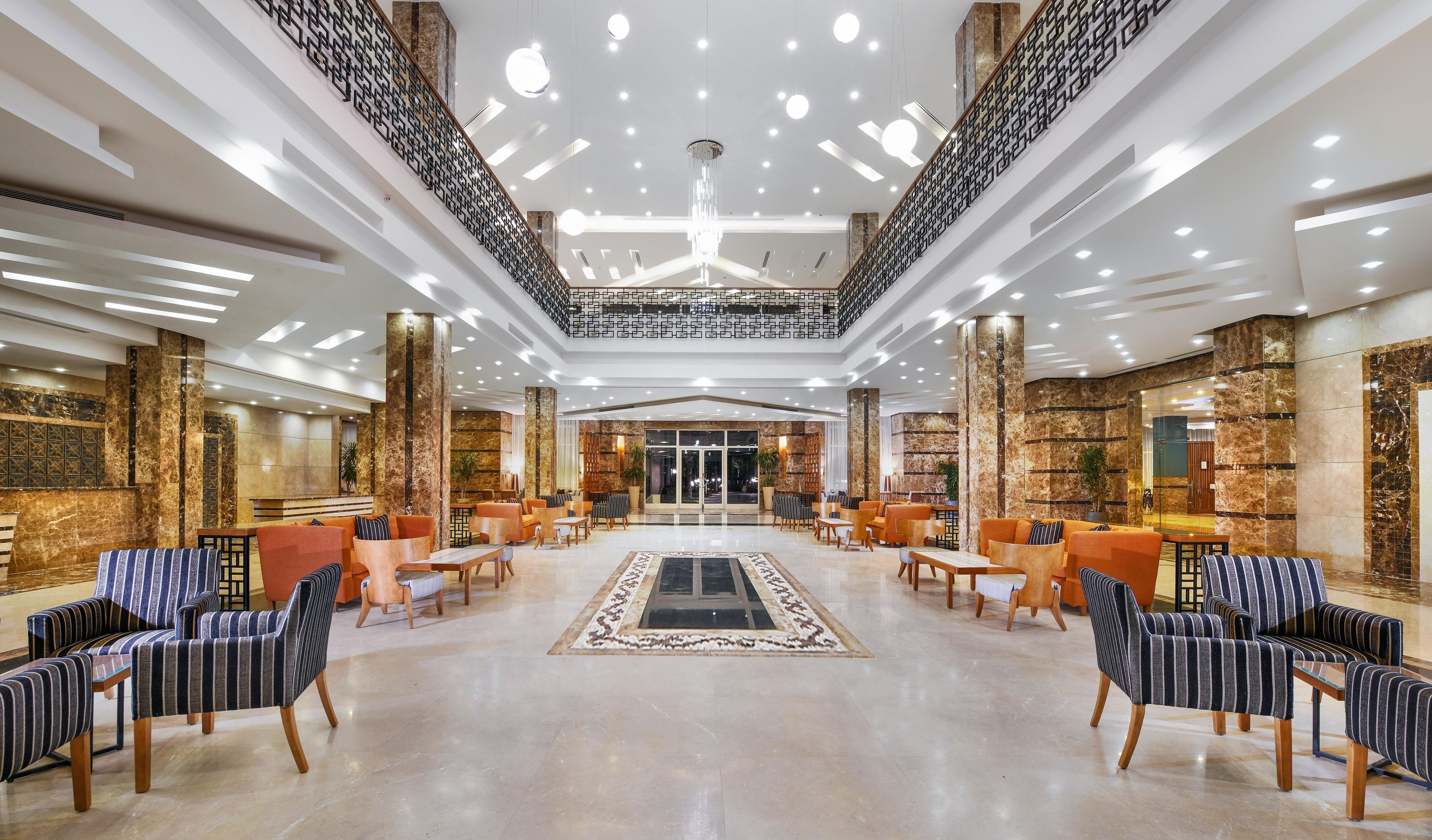 A spacious lobby with a central seating area, high ceilings, and modern lighting fixtures.