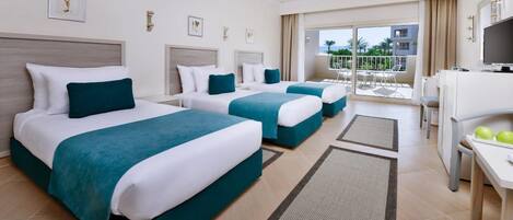 A hotel room with two beds, a TV, a desk, and a balcony with a view.