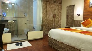A hotel room with a bed, a shower, a toilet, and a vanity with a mirror. - Shaleen Elegance Homestay (Abu Road)