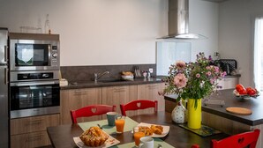 A modern kitchen with a microwave, oven, and a dining area with a table set for breakfast.