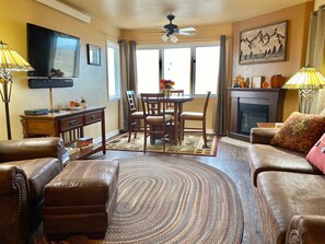 Cozy living room with a seating area, dining table, and fireplace.