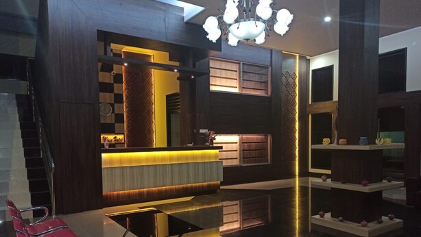 Un hall d’hôtel moderne comprenant un comptoir d’accueil, un espace salon et des éléments décoratifs.
