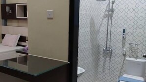 Une salle de bain moderne équipée d’une douche, de toilettes et d’un meuble-lavabo avec un plateau en verre.