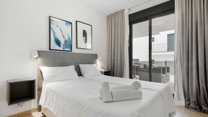 A hotel room with a bed, a TV, and a balcony with curtains. - Alamar apt in Mijas by Costarentals - Ref 38 (Las Lagunas de Mijas)