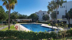 A swimming pool surrounded by greenery and modern buildings. - Alamar apt in Mijas by Costarentals - Ref 38 (Las Lagunas de Mijas)