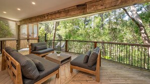 Eine Terrasse im Freien mit Holzmöbeln und Blick auf einen Wald.