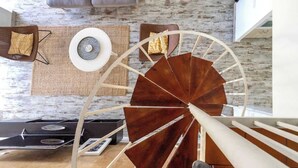 Un intérieur moderne avec un escalier en colimaçon, un canapé et une table basse.