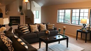 Un salon comprenant un canapé, une table basse et une cheminée.