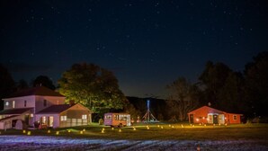 Escena nocturna con casas y un campo.
