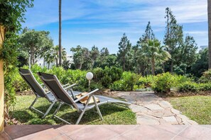 A patio area with two lounge chairs, a hat, and a lamp.