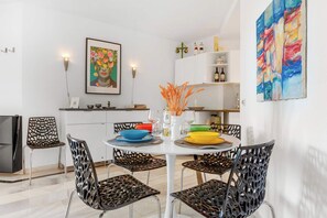 A dining area with a round table, black chairs, and colorful bowls.