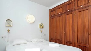 A hotel room with a large wooden wardrobe, a bed with white linens, and two wall-mounted light fixtures. - Central Gem Los Boliches by Costarentals - Ref 77 (Costa del Sol)