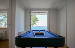 A pool table with a view of the sea through an open door. - Lovely home in Bankeryd with lake view (Bankeryd)
