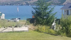Zona residencial con una casa, una bandera y vistas a un lago y montañas.