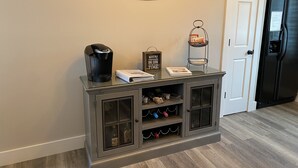 A kitchen with a coffee maker, a welcome sign, a small book, and a wine rack. - In the Heart of Three Oaks - Steps to Downtown (Three Oaks)