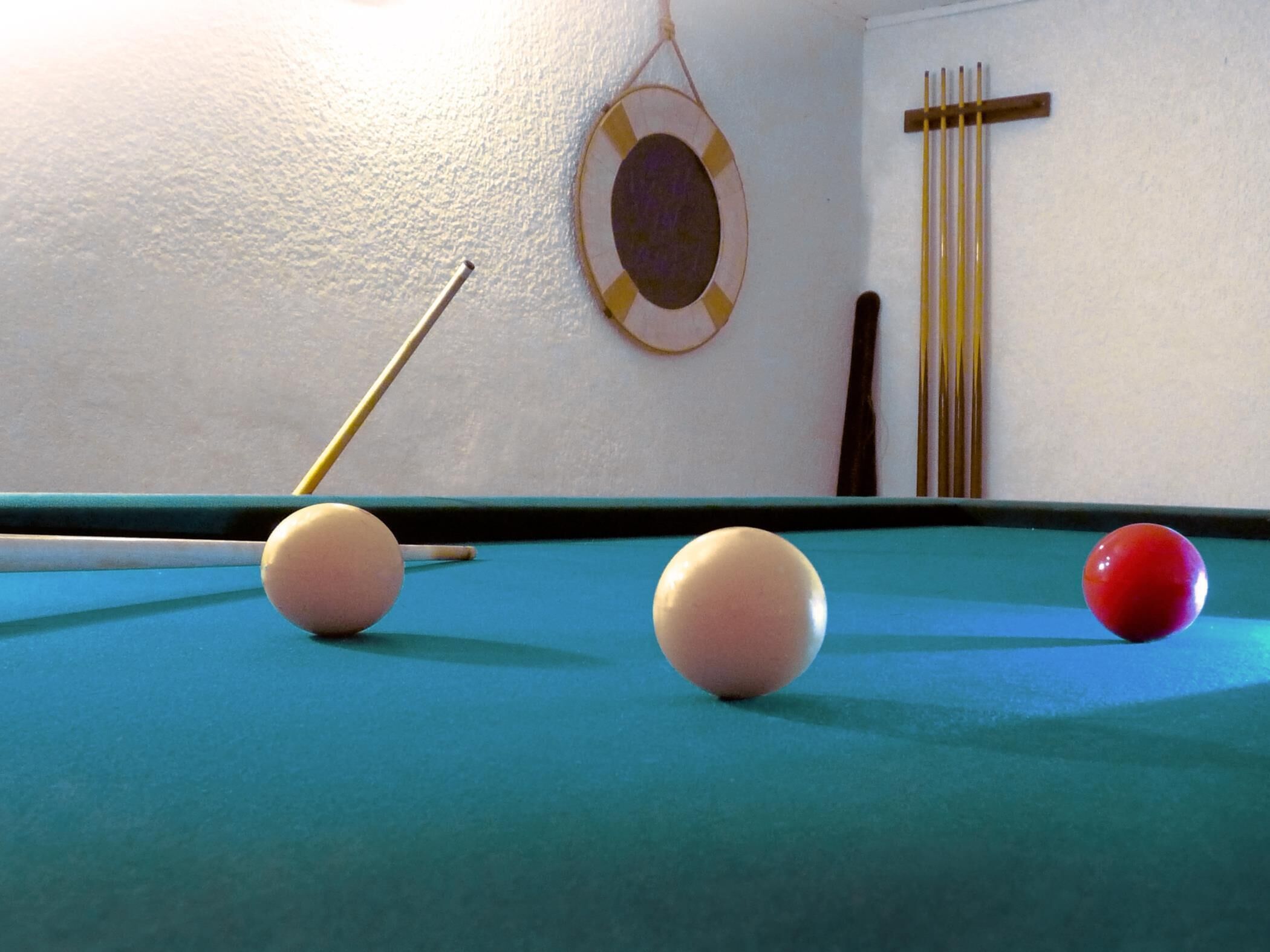 Une table de billard avec trois billes et une queue de billard.