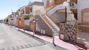 Een rij mediterrane gebouwen met stenen gevels, balkons en een heldere lucht.