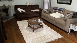 A living room with a brown sofa, beige sofa, a wooden coffee table, and a white rug. - Cozy 3 Bedroom Port Clinton House (Port Clinton)