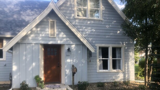 A house with a stone front step, a wooden door, and a mailbox. - Cozy 3 Bedroom Port Clinton House (Port Clinton)