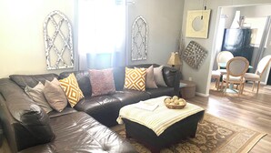 Una sala de estar con un sofá modular, cojines estampados, una mesita auxiliar y una alfombra decorativa.