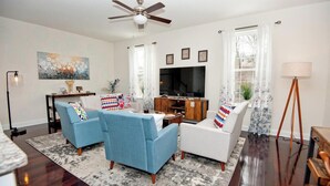 A living room with a ceiling fan, a flat-screen TV, two sofas, a coffee table, and a floor lamp. - Modern Industrial, 12 min walk to Bridge St. (Phoenixville)