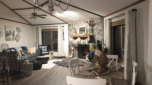 Ein gemütliches Wohnzimmer mit Kamin, Esstisch und einer Couch.