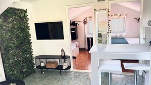 A room with a TV, a small table with a basket, a bed, and a white counter with stools. - Apartment Dolce Vita - 40 m to the sea & Beach-sleeps 3 (Milna)