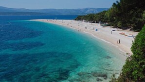 A coastal beach with clear turquoise waters and a sandy shore. - Apartment Dolce Vita - 40 m to the sea & Beach-sleeps 3 (Milna)