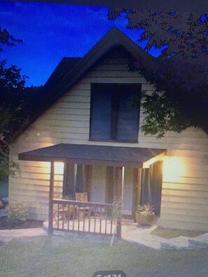 Traditional home with a cozy porch and garage, perfect for relaxation and socializing.