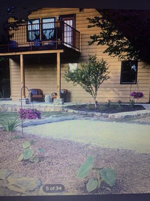 Enjoy outdoor living in this two-story home with a balcony and beautifully landscaped garden featuring a seating area.