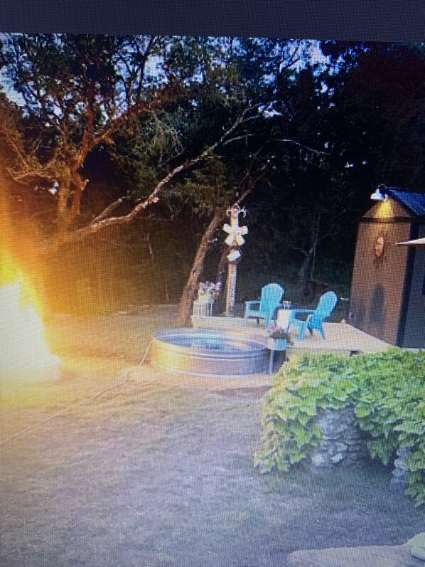 Relax in a serene, outdoor space surrounded by a grassy lawn and a tranquil water feature.