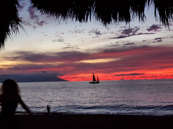 Na praia, espreguiçadeiras, toalhas de praia 