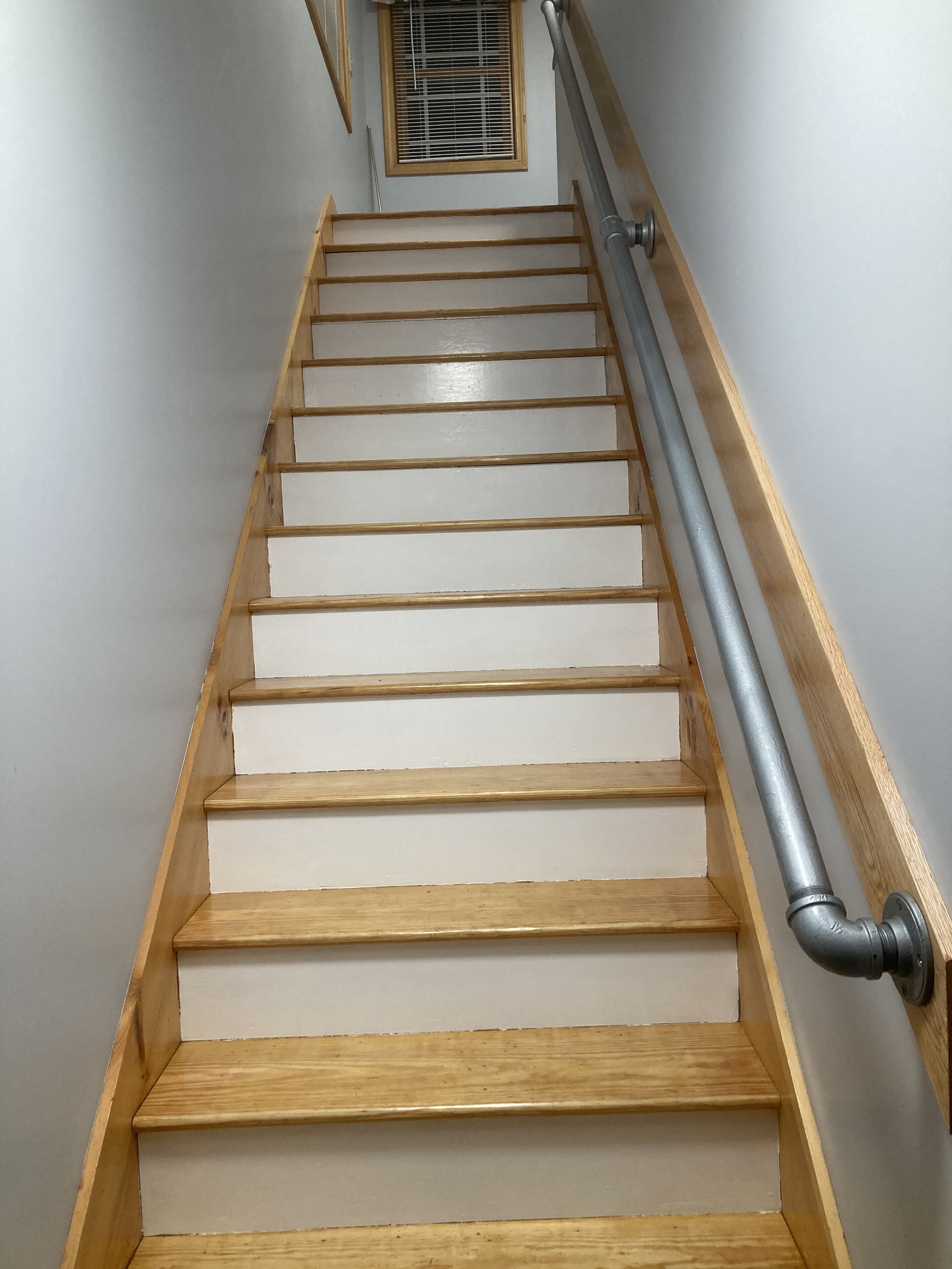 A staircase with wooden steps and a metal handrail.