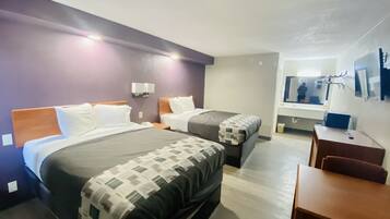 Een hotelkamer met twee bedden, een bureau en een spiegel.