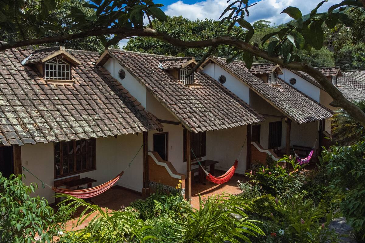 A row of traditional houses with tiled roofs, surrounded by lush greenery.